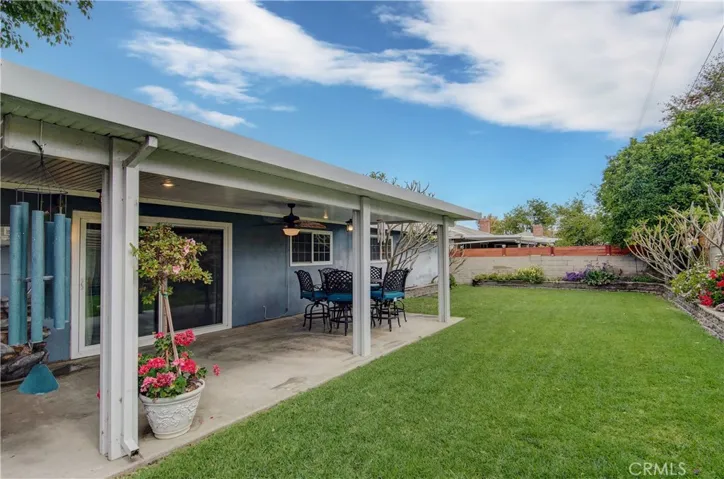 Large grass backyard with covered patio