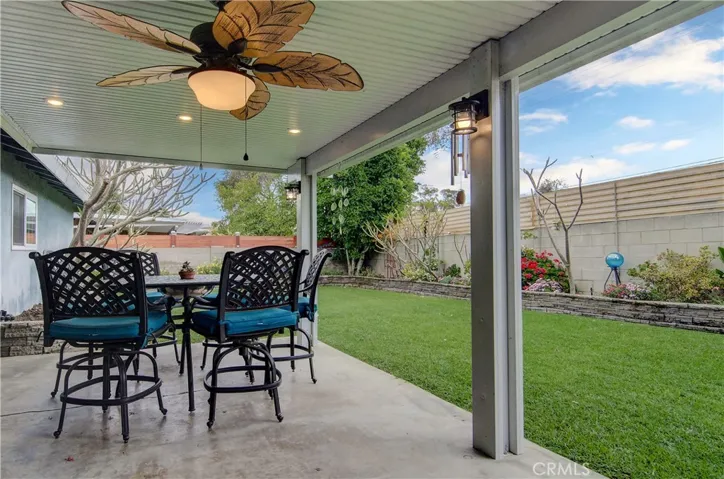 Covered patio has recessed lighting and a ceiling fan.