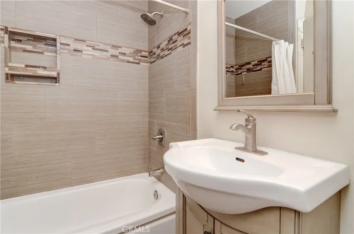 Tiled shower goes all the way up to the ceiling.