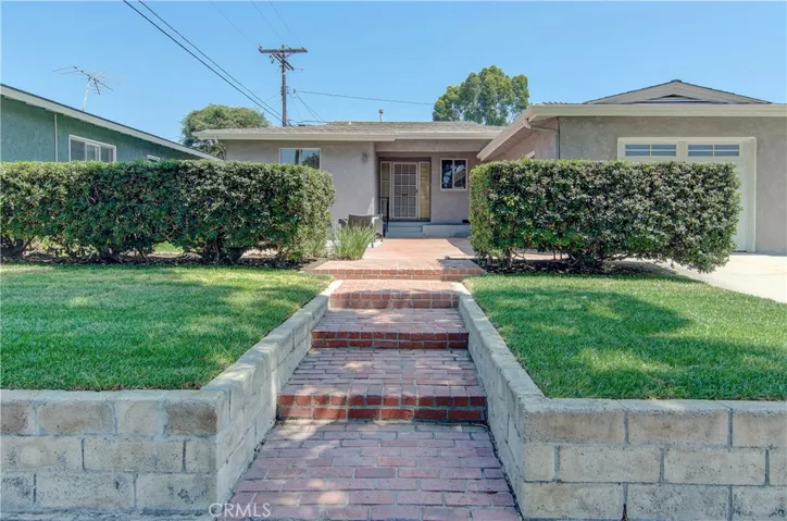 Wide brick walkway and raised lawn are a nice greeting for friends and family.