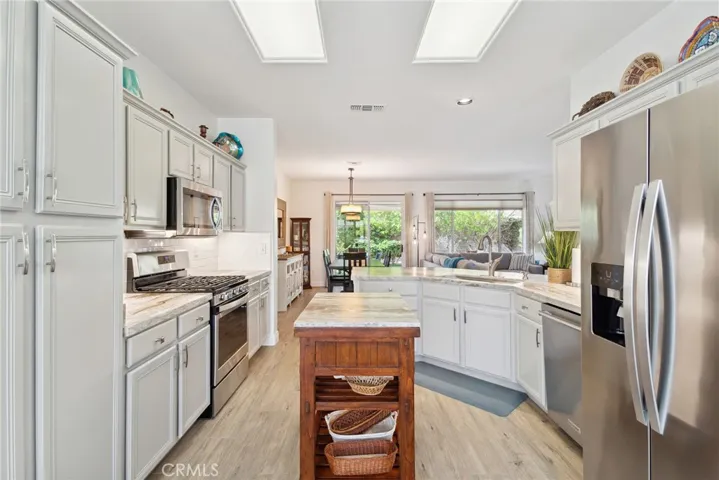 SPACIOUS KITCHEN WITH ISLAND, STAINLESS SATIN FINISHED APPLIANCES, GRANITE COUNTER TOPS.