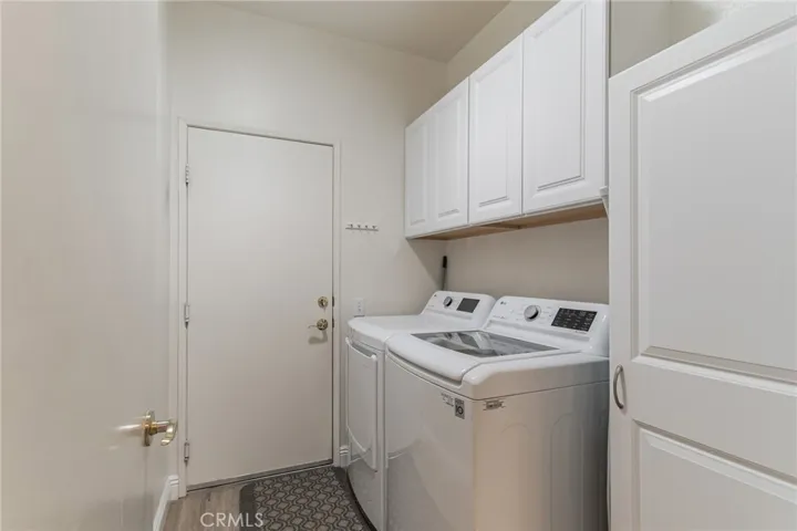 SEPARATE LAUNDRY ROOM WITH STORAGE CABINETS.