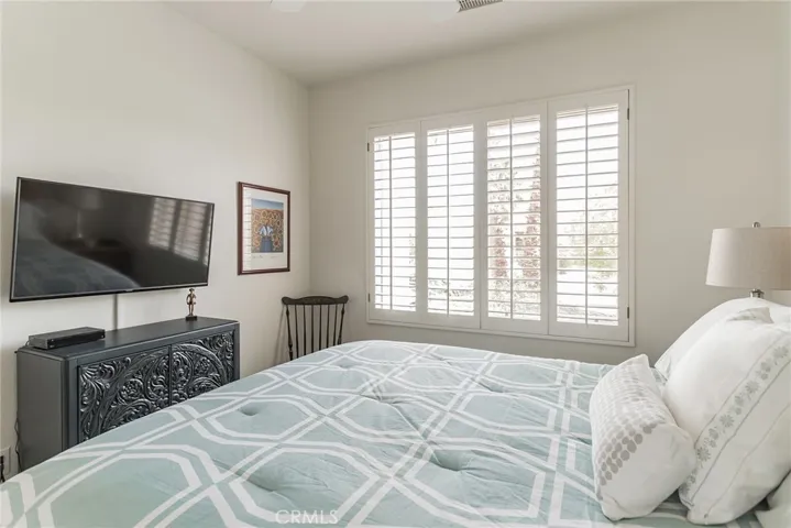 THIRD BEDROOM FACES THE FRONT OF THE HOUSE. WOOD SHUTTERS AND A FAN.