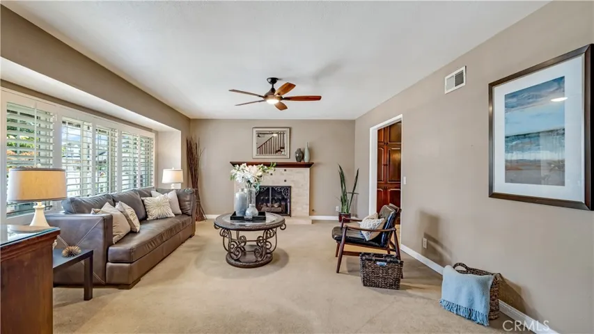 This lovely living room has a working gas fireplace and plantation shutters