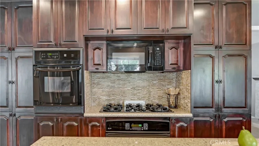 Two wall ovens, one is convection, 5 burner gas stove, and storage above the stove reflect the care and attention put into this home