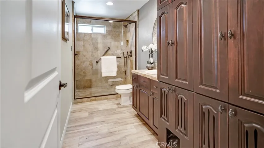 The downstairs bathroom with its beautiful wood cabinets has a built in kitty en-suite for its litter box (in lower center of photo)