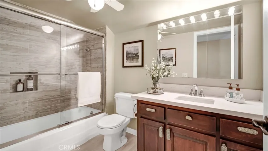 Upstairs hall bathroom has a bathtub and wood-like wall tiles
