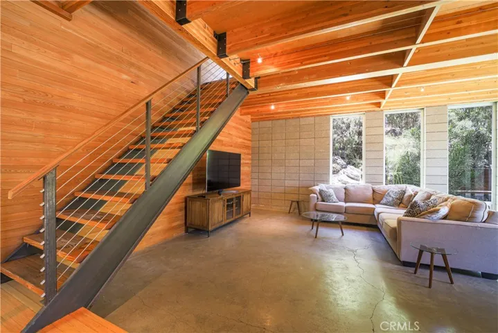 Living room. The stairs lead to the upper level primary suite