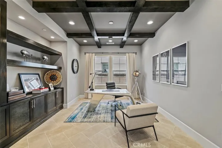 Home office with beamed ceiling, built-in cabinets and shelves.