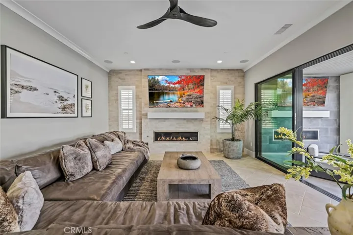 The great room with brick-tile accent wall, fireplace, surrounding sound system, and multi-sliding doors that open up to the patio for the perfect indoor-outdoor living.