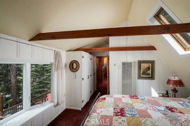 UPPER LEVEL BEDROOM WITH SKY LIGHTS AND VIEWS OF BACKYARD FOREST.