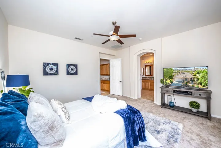Master bedroom with new carpet, ceiling fan, and direct covered patio access.
