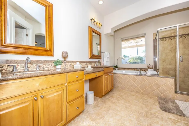 Master bathroom with granite counters, designer backsplash, dual sinks, sunken tub and walk in shower.