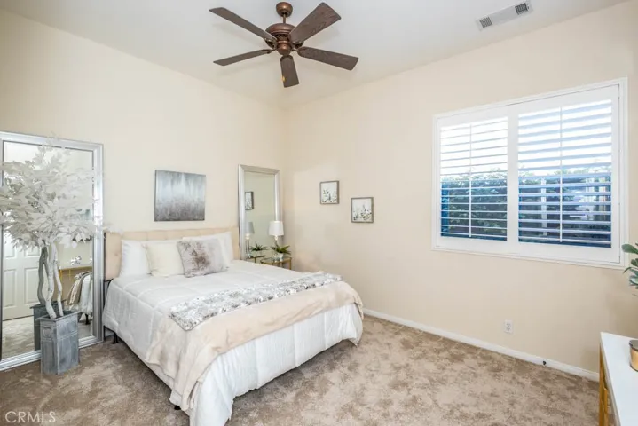 Third bedroom with new carpet, ceiling fan, and walk in closet.