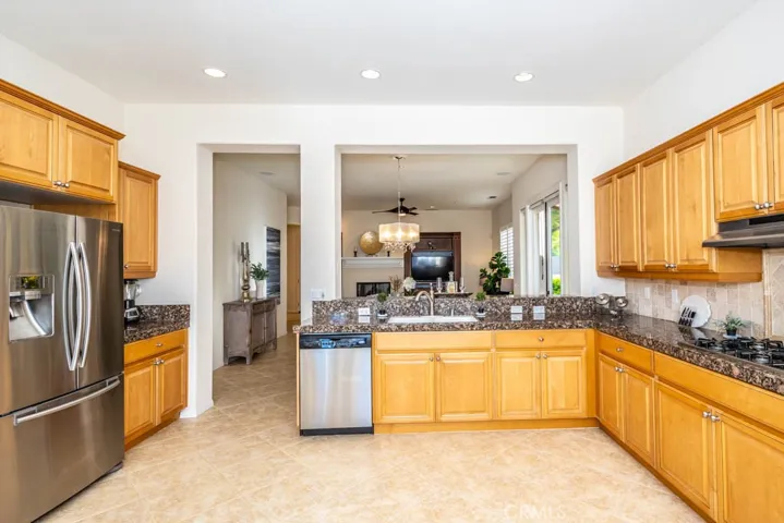 North view of the kitchen with stainless steel appliances, tile flooring, and granite counters.