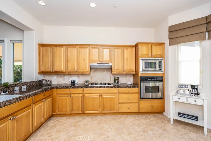 Kitchen with granite counters, plenty of counter space and cupboards, and rexcessed lighting.