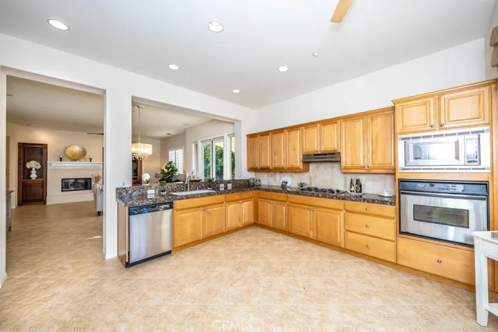 Northeast view of the kitchen with granite counters, stainless steel appliances, and plenty of cupboard space.