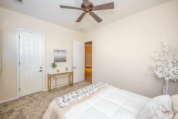 Third bedroom with new carpet, ceiling fan, and walk in closet.