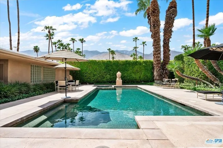 Large, pebbled pool and spa in front courtyard