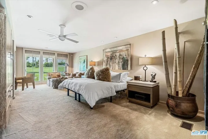 Primary bedroom suite opens to course and has a seating area