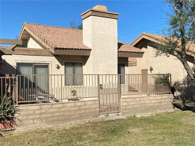 Side of condo with a block and iron work good sized patio.