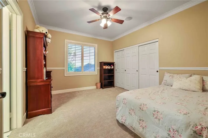 Bedroom upstairs with custom two-tone paint, recessed lights, ceiling fan, crown moldings, carpet.