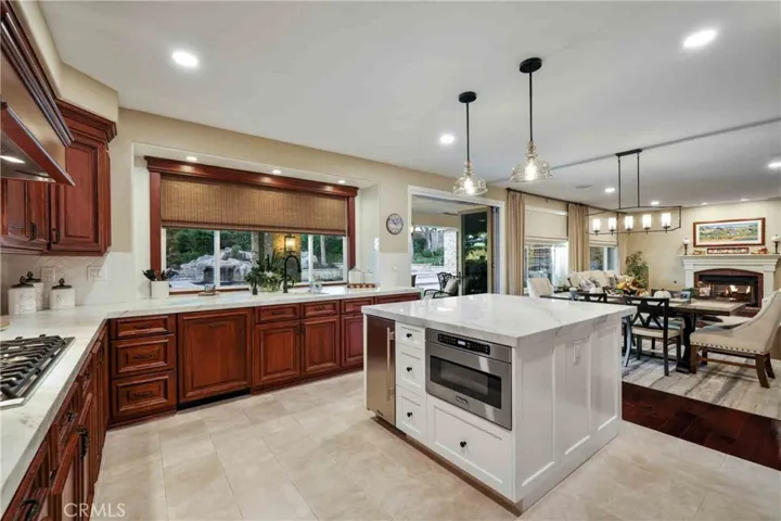Gourmet kitchen with marble counter tops, full backsplash, center island, newer stainless-steel appliances, including 48” Viking built-in refrigerator, built-in microwave, 6-burner cook top, Café Double Ovens, True ice machine, food warmer, and Bosch Dishwasher.
