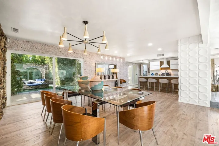 Dining looking to the newly remodeled kitchen and side patio with barbecue and more seating
