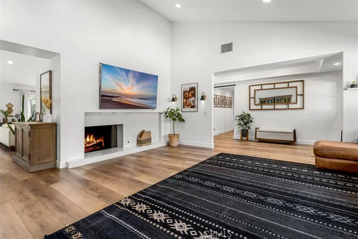 The living room has a fireplace and high ceilings.