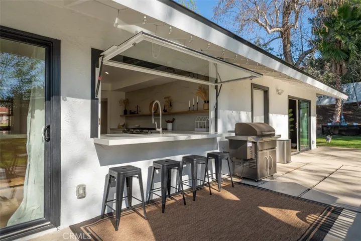Outdoor bartop seating in front of the kitchen window.
