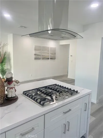 Center Island with 5-burner gas cooktop and stainless/glass exhaust hood