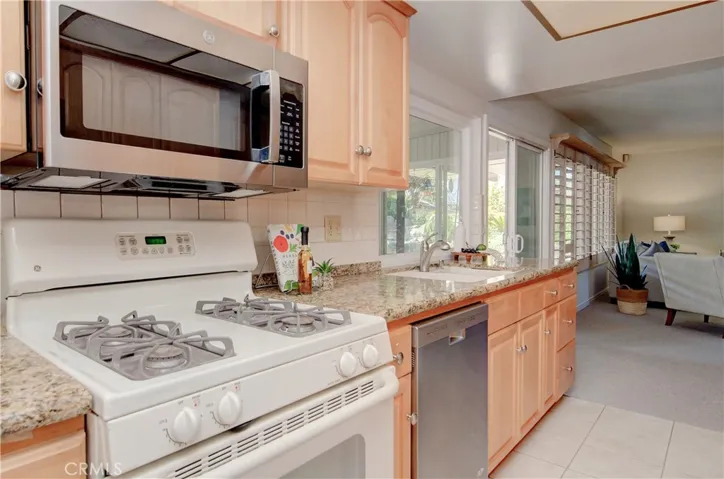 Updated kitchen has stone counters and stainless accents.