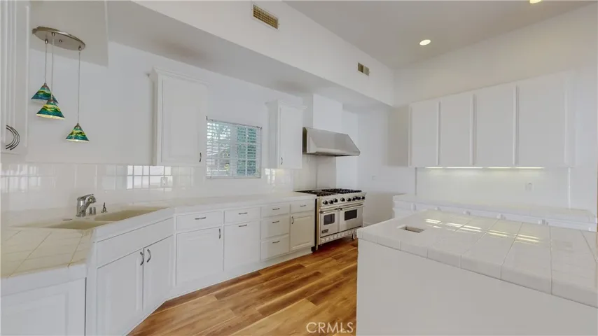 Full kitchen with range and hood, dining area, cabinetry and counter tops galore