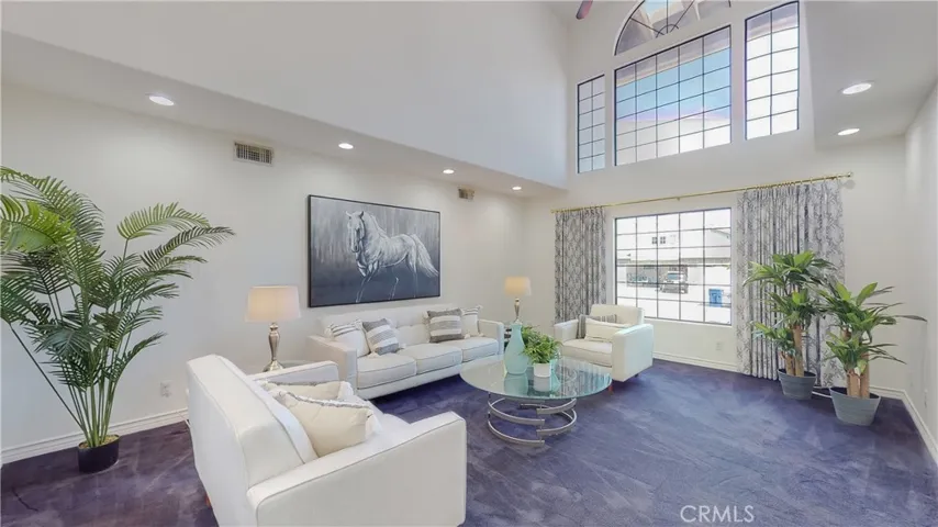 Step down into to this inviting living room with double high ceilings, bathed in natural lighting.