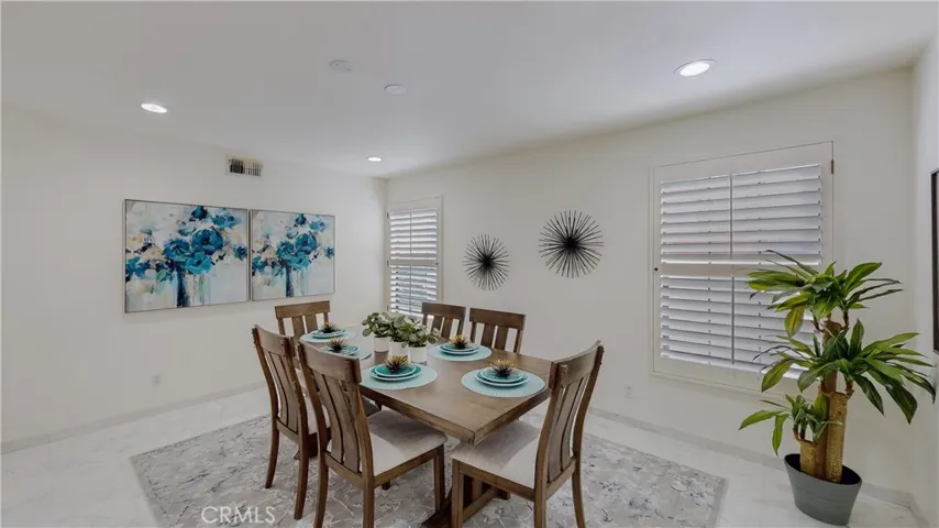 Featuring a large formal dining with plantation shutters and canned lighting and marble flooring