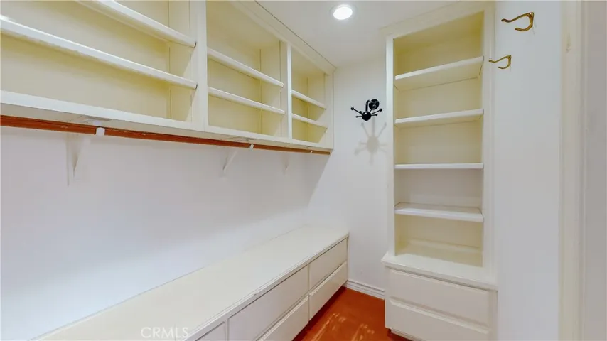 Ample size walk-in closet with dresser drawers and hanging racks