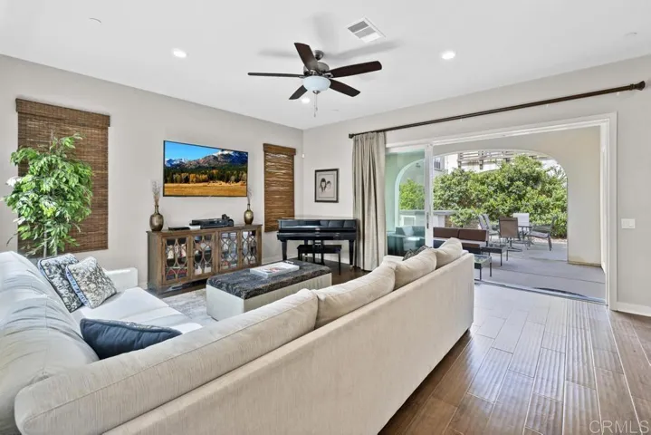 Spacious Living Room with Large TV, Baby Grand Piano, Ceiling Fan and Large Slider to Covered Patio