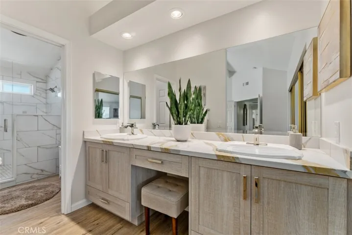 The primary suite bathroom features comfort height dual sink vanity and a large walk-in shower