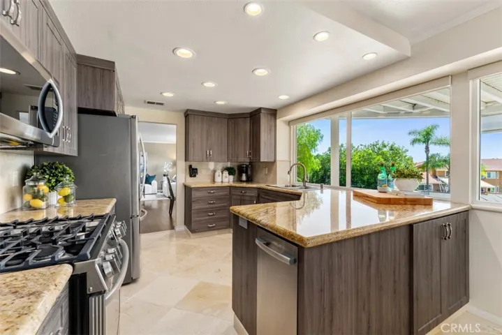 The remodeled kitchen overlooks the covered patio, pool, and expansive back yard.