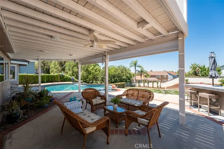 [photo was taken prior to the new landscaping in the lower yard]. Patio cover features recessed lights and ceiling fan. The custom BBQ island has electricity. a natural gas BBQ (no propane tanks!), and bar top for dining and entertaining.