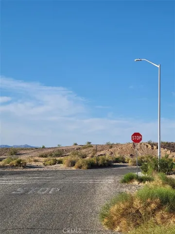 Paved street, sidewalk, and street lights on north boundary.