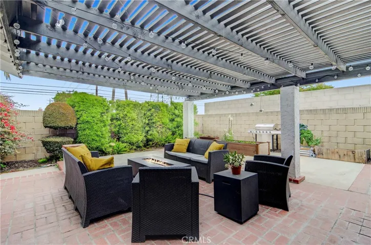Private outdoor lounge, with high privacy walls and greenery. Pergola covering with string lights perfect for year long get-togethers