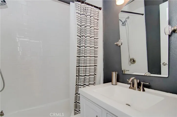 One of two full bathrooms. New vanity paired with swivel mirrors and copper faucet