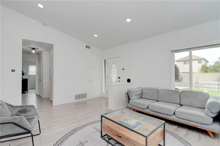 Living room and entry with ornate glass front door