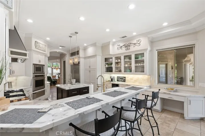 Exceptional Newly remodeled gourmet Chef's kitchen with elegant Italian marble counter tops, New custom cabinetry, dining counter, New high end appliances, New designer light fixtures, two New farm sinks, New faucets, walk-in pantry, tech center, center island with sink & dining area