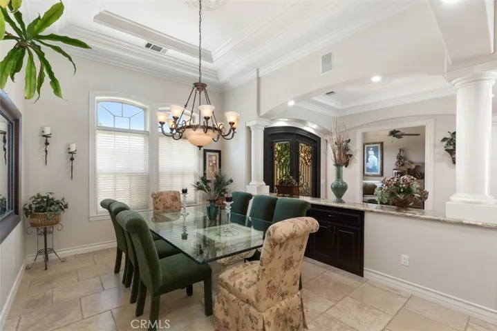 Formal dining with coffered ceiling, crown molding and custom built-ins