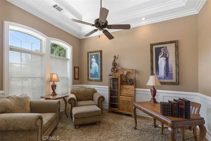 Parlor/office with wainscoting, ceiling fan, coffered ceiling and crown molding