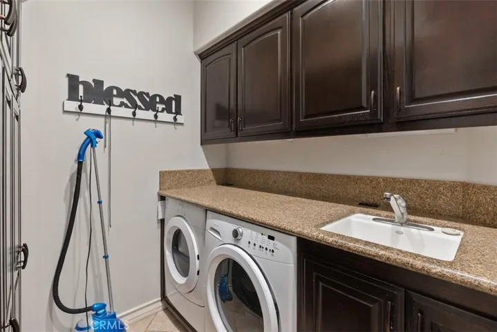laundry room with sink and storage cabinets