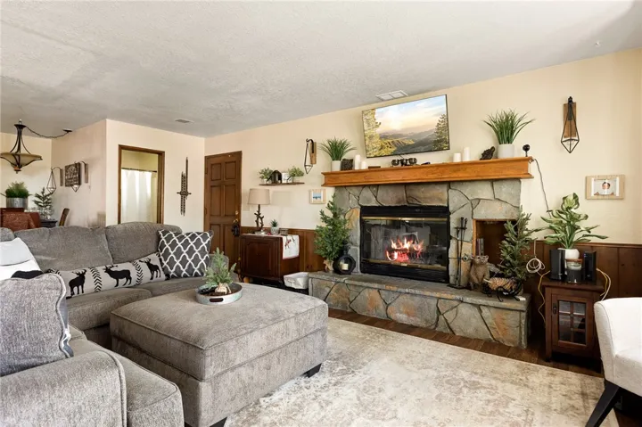 Flag stone raised hearth in greys and gold tones. Gorgeous wood mantle and bead board aroung the living room.