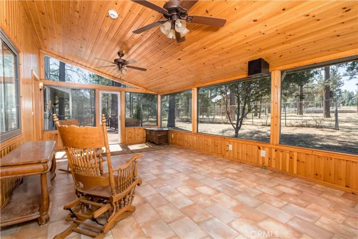 Enclosed Sun Room with great views through the pines to the barn and equestrian areas